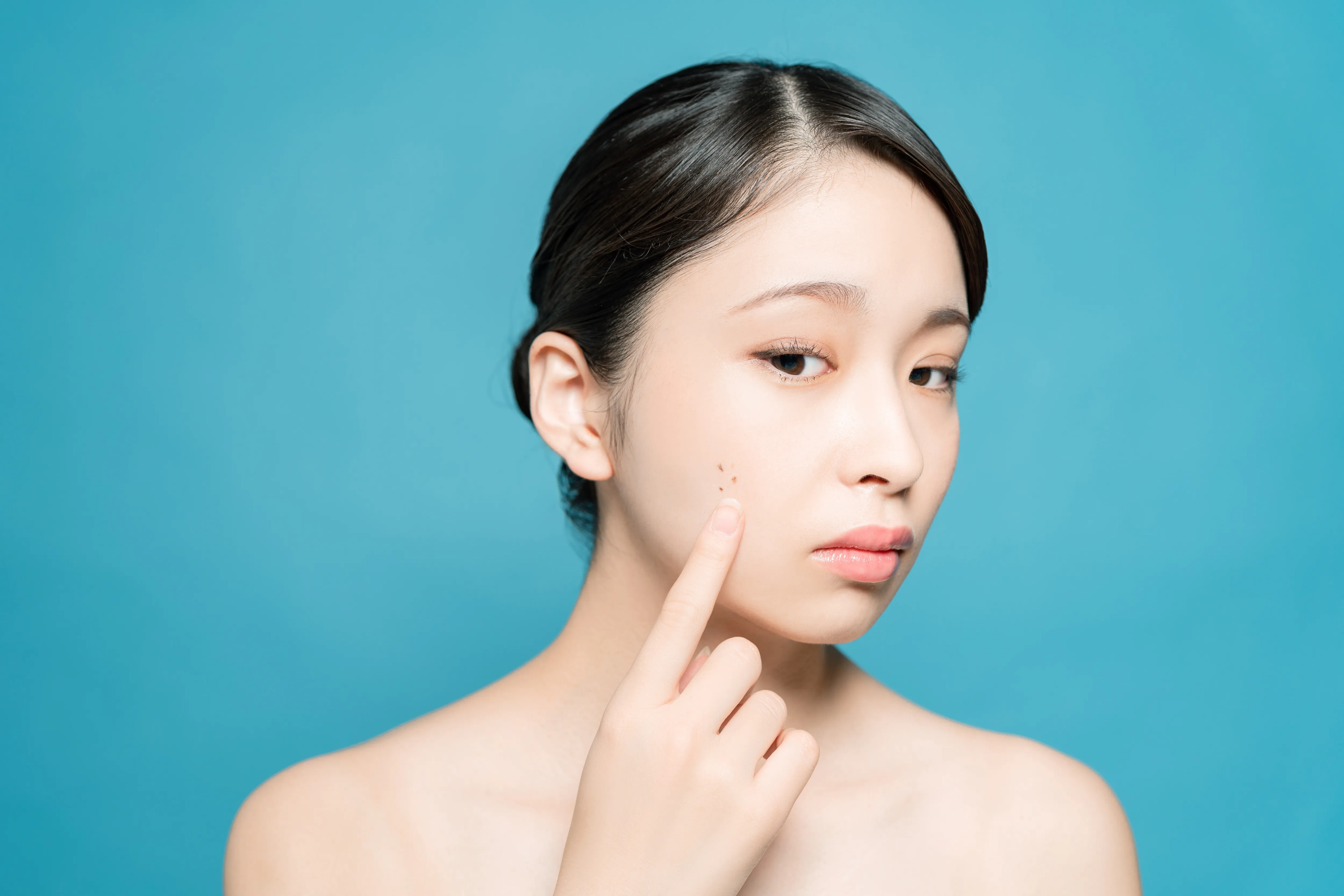 顔のホクロが気になる女性